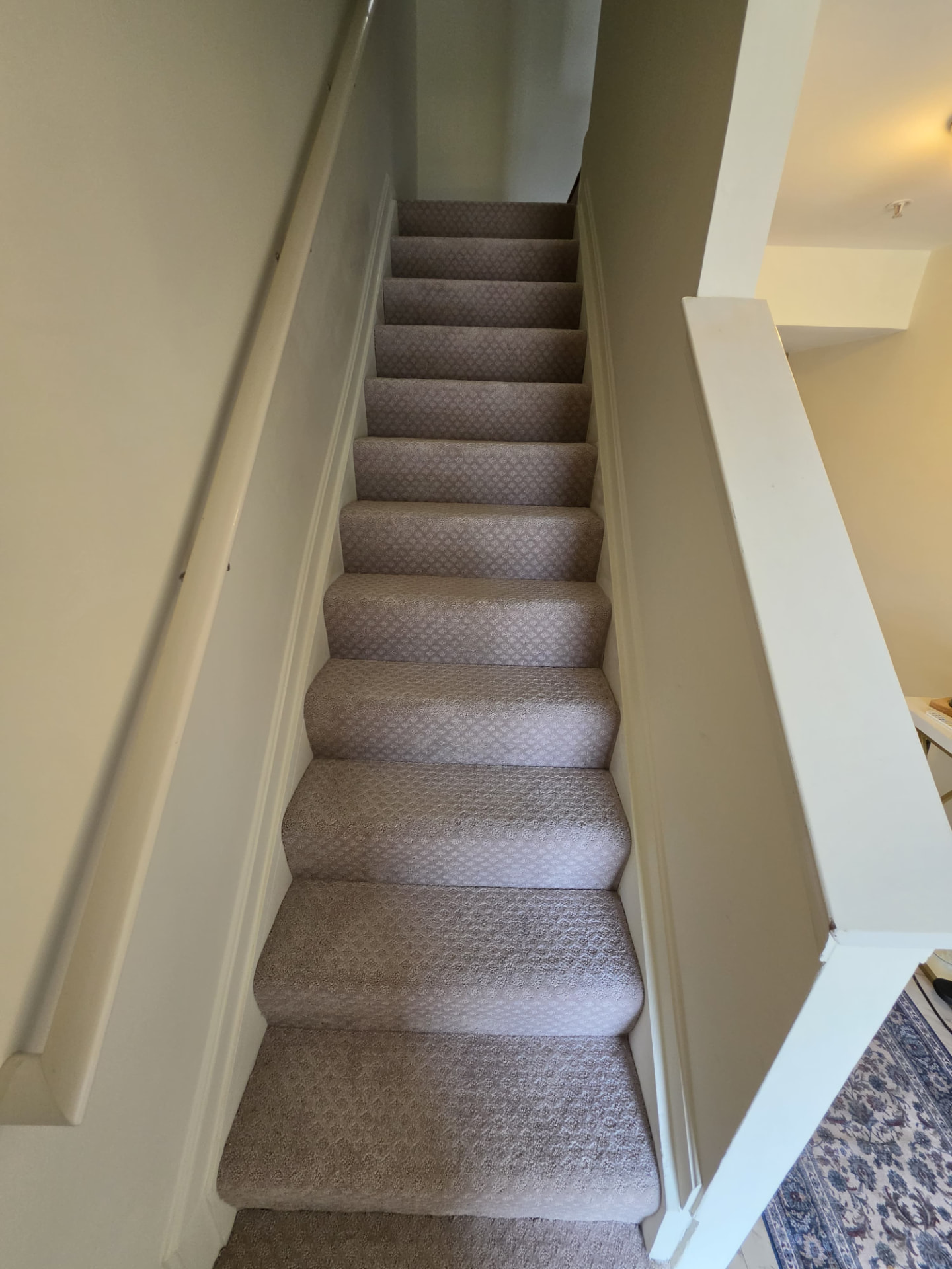After — Stairway remodel — walls and trim repainted, new carpet installed